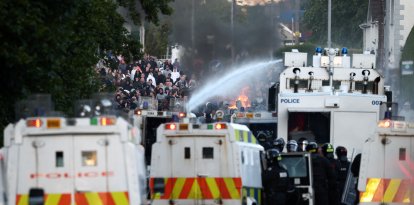 La policía utiliza un cañón de agua mientras bloquea el paso a los manifestantes en Glengormley, al norte de Belfast