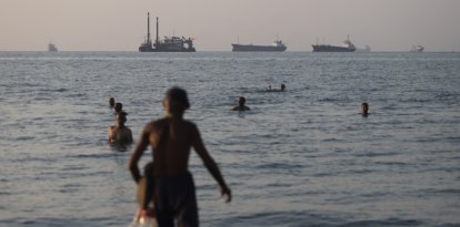 Embarcaciones de carga y comerciales ancladas en el Estrecho de Ormuz, mientras los residentes de Bandar Abbas se entretienen en el agua.