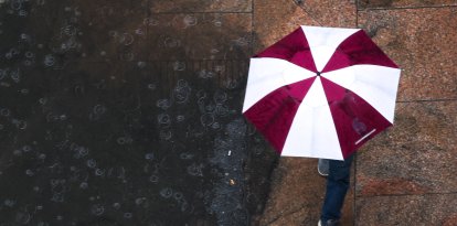 Una persona camina con una sombrilla bajo la lluvia (Archivo)