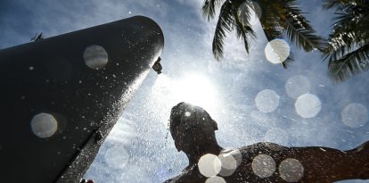 Un hombre se ducha en medio de una calurosa tarde en Miami Beach (Archivo)