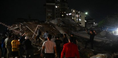 Personas de pie junto a un edificio derrumbado tras un terremoto en Caracas el 24 de junio de 2026.