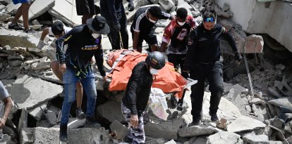Los voluntarios rescatan cuerpos atrapados entre los escombros tras el terremoto en Venezuela