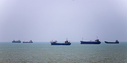 In this picture obtained from Iran's ISNA news agency on June 18, 2026, vessels are seen anchored in Bandar Abbas along the Strait of Hormuz. Oil prices tumbled after Trump and his Iranian counterpart separately signed their accord to end the Middle East war, with the Strait of Hormuz to reopen but two months of negotiations lying ahead. (Photo by AMIRHOSSEIN KHORGOOEI / ISNA / AFP) /