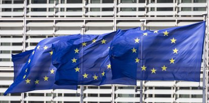 Flags of Europe as seen waving from the flagpoles in front of the EU Commission headquarters.