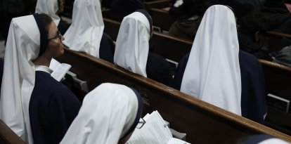 A nun looks through the program of the Solemn Vespers evening prayer at St. Patrick's Cathedral in New York