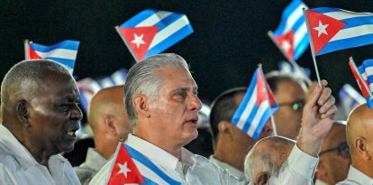 Miguel Díaz-Canel (derecha), y el presidente del Parlamento, Esteban Lazo, ondean banderas de papel durante la celebración del 73.º aniversario del asalto guerrillero al Cuartel Moncada