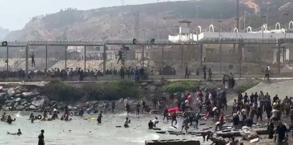 Esta captura de vídeo de AFP muestra a migrantes llegando a la costa del enclave español de Ceuta, en el norte de África, tras nadar alrededor de la valla fronteriza entre Marruecos y España, en Ceuta, el 30 de julio de 2026.