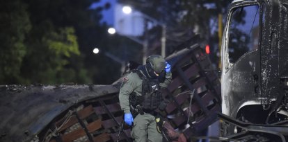 Un policía inspecciona el lugar tras la explosión de un camión