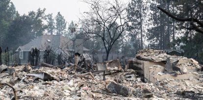 Los escombros de una vivienda residencial calcinada siguen ardiendo lentamente en el barrio de Balboa, en Spokane (Washington), el 2 de agosto de 2026. Los incendios, que avanzaron a gran velocidad, dejaron un rastro de destrucción el domingo en la ciudad de Spokane, situada en el noroeste de Estados Unidos, y las autoridades informaron de que cientos de edificios quedaron reducidos a cenizas.