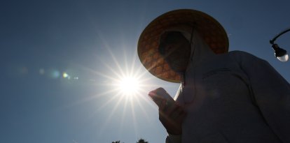 Una persona intenta cubrirse del sol en California