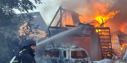 Rescatistas ucranianos trabajando para extinguir un incendio en una casa tras un ataque aéreo