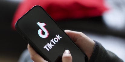 Una niña sostiene un iPhone 16 con el logotipo de la aplicación TikTok/ Jan Woitas
