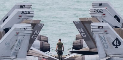 Un miembro de la tripulación camina por la cubierta de vuelo del portaaviones nuclear estadounidense USS Abraham Lincoln