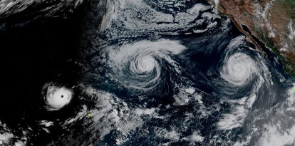 This handout satellite image obtained from the National Oceanic and Atmospheric Administration (NOAA)/GOES shows Hurricane Lowell (L).