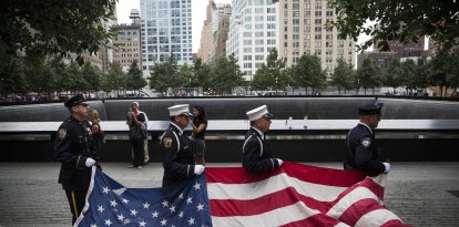 Miembros del Departamento de Policía de Nueva York, del Cuerpo de Bomberos de Nueva York y del Departamento de Policía de la Autoridad Portuaria portan una bandera de Estados Unidos al inicio de los actos conmemorativos celebrados en el emplazamiento del World Trade Center, en Nueva York, el 11 de septiembre de 2014. Este año se cumple el 13.º aniversario de los atentados terroristas del 11 de septiembre, en los que murieron casi 3.000 personas en el World Trade Center, el Pentágono y en el vuelo 93.