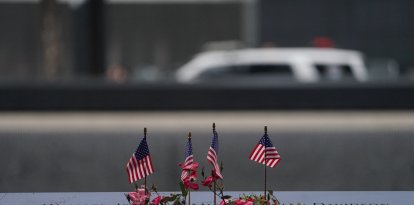 Banderas estadounidenses y flores adornan el estanque conmemorativo del Monumento Nacional del 11 de Septiembre