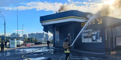 Un policía extinguiendo un incendio en una gasolinera dañada tras un ataque con drones rusos en Kiev
