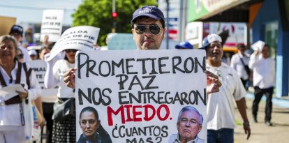 Un manifestante sostiene una pancarta que dice "Prometieron paz. Nos entregaron miedo" durante la Marcha por la Paz en Culiacán.