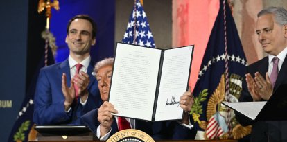 US President Donald Trump displays an executive order on artificial intelligence