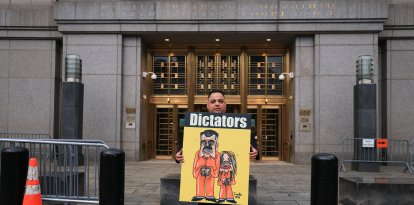 Un manifestante sostiene un cartel con una ilustración del derrocado presidente venezolano Nicolás Maduro y su esposa Cilia Flores, frente al tribunal federal donde tienen lugar las audiencias previas al juicio.