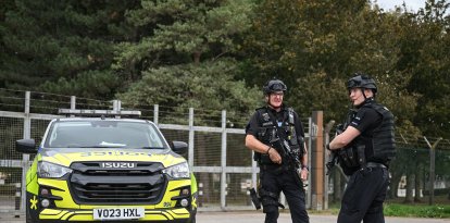 Agentes de policía armados montan guardia en un control de carretera situado en una de las entradas de la base de la RAF Fairford, en Fairford, al suroeste de Inglaterra, el 27 de septiembre de 2026, mientras la policía antiterrorista del Reino Unido investiga un incidente ocurrido cerca de la base, en la localidad de Whelford. El 27 de septiembre, la policía británica declaró un incidente grave y evacuó a los vecinos que vivían cerca de una base utilizada por la Fuerza Aérea de los Estados Unidos tras detener a varios hombres como sospechosos de delitos relacionados con explosivos.