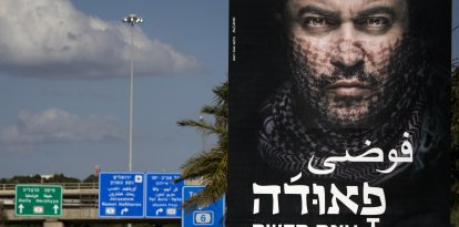 Una fotografía tomada el 31 de diciembre de 2017 en la ciudad israelí de Tel Aviv muestra una valla publicitaria con texto en árabe y hebreo que promociona la nueva temporada de la exitosa serie de televisión israelí «Fauda». La segunda temporada de «Fauda», una exitosa serie de televisión israelí cuyo estreno está previsto para más tarde esta noche, ha provocado una protesta pública por parte de los vecinos, que se sienten intimidados por los carteles. La aclamada serie de ficción profundiza en las complejidades del conflicto israelo-palestino a través de la historia de una unidad de agentes encubiertos.