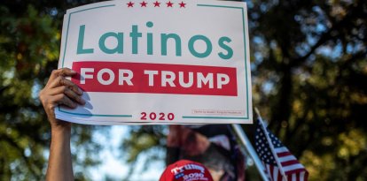 Un hombre sostiene un cartel de "Latinos por Trump" en una protesta tras la victoria de Joe Biden en las elecciones presidenciales de 2020, en Austin, Texas, el 7 de noviembre de 2020.