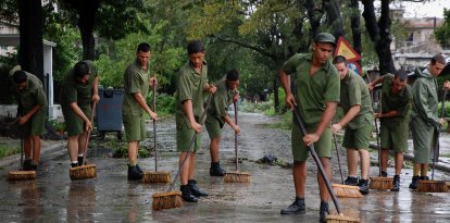 Reclutas cubanos barren una calle de La Habana en 2008 tras el paso del devastador huracán Ike