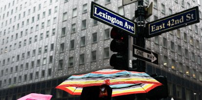 Varias personas caminan bajo la lluvia cerca de la terminal Grand Central en Nueva York