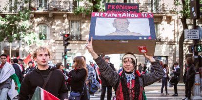 Manifestantes con una pancarta y un cartel durante una manifestación en apoyo a Palestina en París