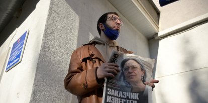 Un hombre sostiene un periódico con la foto de la periodista de investigación Anna Politkovskaya