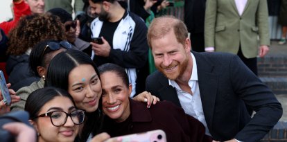 El príncipe Harry, duque de Sussex, y su esposa Meghan, saludan a los asistentes a su salida tras su visita al Community Recording Studio