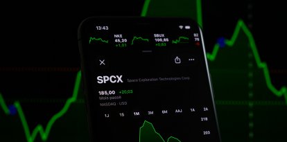 El precio de las acciones de SpaceX se muestra en la pantalla de un teléfono inteligente con un gráfico bursátil de fondo (imagen referencial).