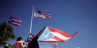 Imagen de archivo y de referencia que muestran manifestantes con la bandera de Puerto Rico