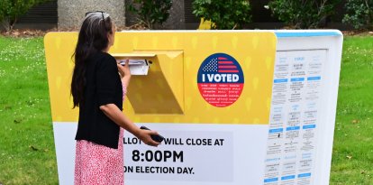 Un votante deposita su boleta en un buzón electoral durante la votación anticipada (Archivo)