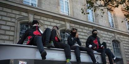 Manifestantes se sientan en el tejado de un baño público en París