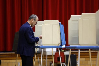 Elecciones presidenciales 2024: Imagen de archivo de un votante depositando una papeleta en un colegio electoral en Michigan.