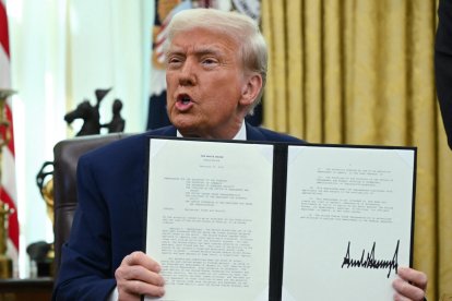 El presidente Donald Trump, habla mientras muestra la orden ejecutiva sobre aranceles recíprocos que firmó el 13 de febrero de 2025. (Foto de ANDREW CABALLERO-REYNOLDS / AFP)