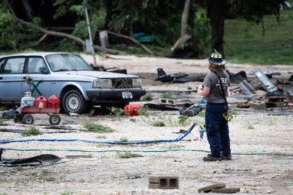 Un bombero toma un descanso con vistas a las secuelas en el GoodWater RV Park en Georgetown, donde la crecida del río San Gabriel ha producido peligrosas inundaciones