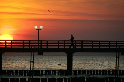Un hombre solitario camina por un muelle