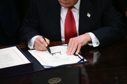 El presidente de Estados Unidos, Donald Trump, firma el paquete de proyectos de ley para reabrir el gobierno federal en el Despacho Oval de la Casa Blanca en Washington, D.C., el 12 de noviembre de 2025. El Congreso puso fin el miércoles al cierre gubernamental más largo de la historia de Estados Unidos, 43 días que paralizaron Washington y dejaron sin sueldo a cientos de miles de trabajadores, mientras republicanos y demócratas se enzarzaban en un juego de culpar al otro. La Cámara de Representantes, controlada por los republicanos, votó en gran medida siguiendo la línea del partido para aprobar un paquete aprobado por el Senado que reabrirá los departamentos y agencias federales, mientras muchos demócratas se indignan por lo que consideran una capitulación de los líderes del partido.