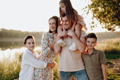 Familia formada por padre, madre y tres hijos, uno de ellos en hombros de su padre