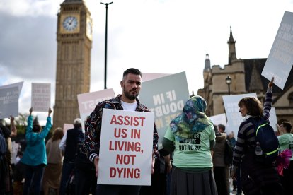 Un activista que se opone a la modificación de la ley sobre la muerte asistida sostiene una pancarta frente al Palacio de Westminster, sede de las Cámaras del Parlamento en el centro de Londres, el 11 de septiembre de 2026. Los legisladores del Reino Unido volverán a debatir la legalización de la muerte asistida, después de que la controvertida ley fuera aprobada por la Cámara Baja el año pasado, antes de que la Cámara Alta —cuya composición no es electiva— la echara por tierra con más de 1.200 enmiendas.
