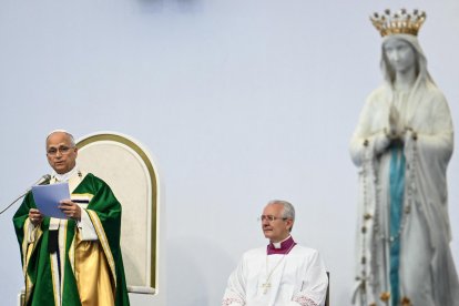 El papa León XIV (izquierda), flanqueado por el arzobispo italiano y maestro de las celebraciones litúrgicas pontificias Diego Ravelli, celebra, junto a la estatua de la Virgen María coronada, también conocida como «Nuestra Señora de Lourdes», la Santa Misa en la pradera del Santuario de Nuestra Señora de Lourdes, en el suroeste de Francia, el 27 de septiembre de 2026, en el tercer día de su visita a Francia.