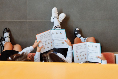 Varios niños leen un libro en la escuela.
