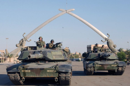 Tankes Abraham posan para una foto bajo el "Arco de la Victoria" en la Plaza de la Ceremonia, Bagdad, Irak, durante la Operación Libertad Iraquí.