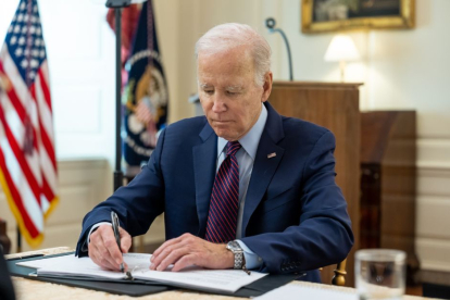 El presidente Joe Biden firma en el despacho oval.