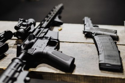 Un rifle de asalto y una pistola en un campo de entrenamiento de tiro. Imagen de archivo.
