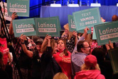 Hispanos con carteles que rezan "Latinos for Trump" en 2020.