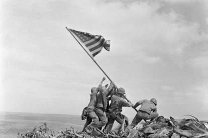 Marinos americanos levantan la bandera estadounidense en Iwo Jima durante las últimos coletazos de la Segunda Guerra Mundial.